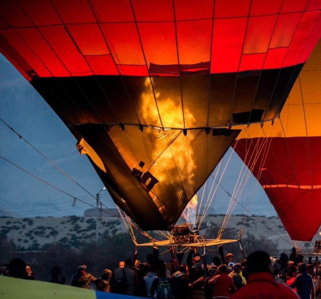 Ground crew inflating an Adventure Balloon envelope on the Luxor West Bank launch field before dawn