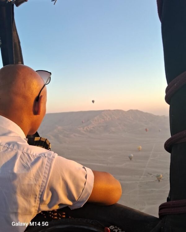 Captain Ali flying over Luxor's West Bank at sunrise, other balloons in the distance