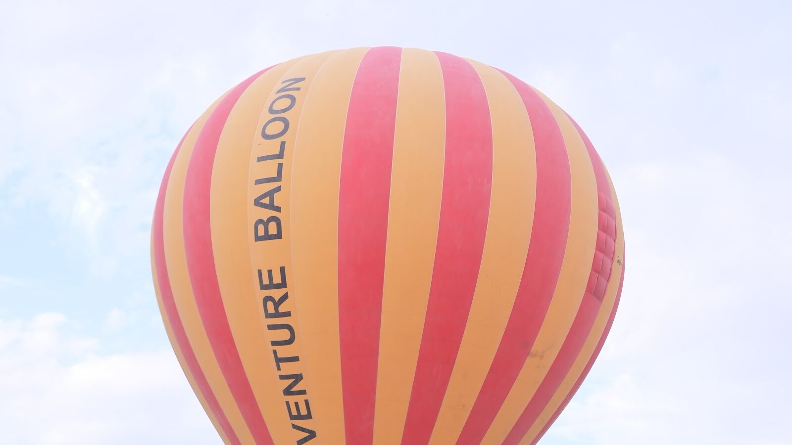 An Adventure Balloon envelope lifting off