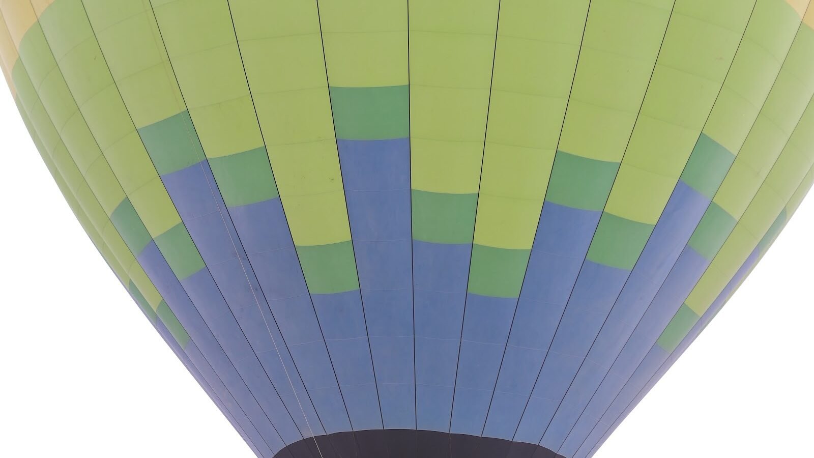 The striped canopy of a large hot air balloon standing inflated on the Luxor launch field