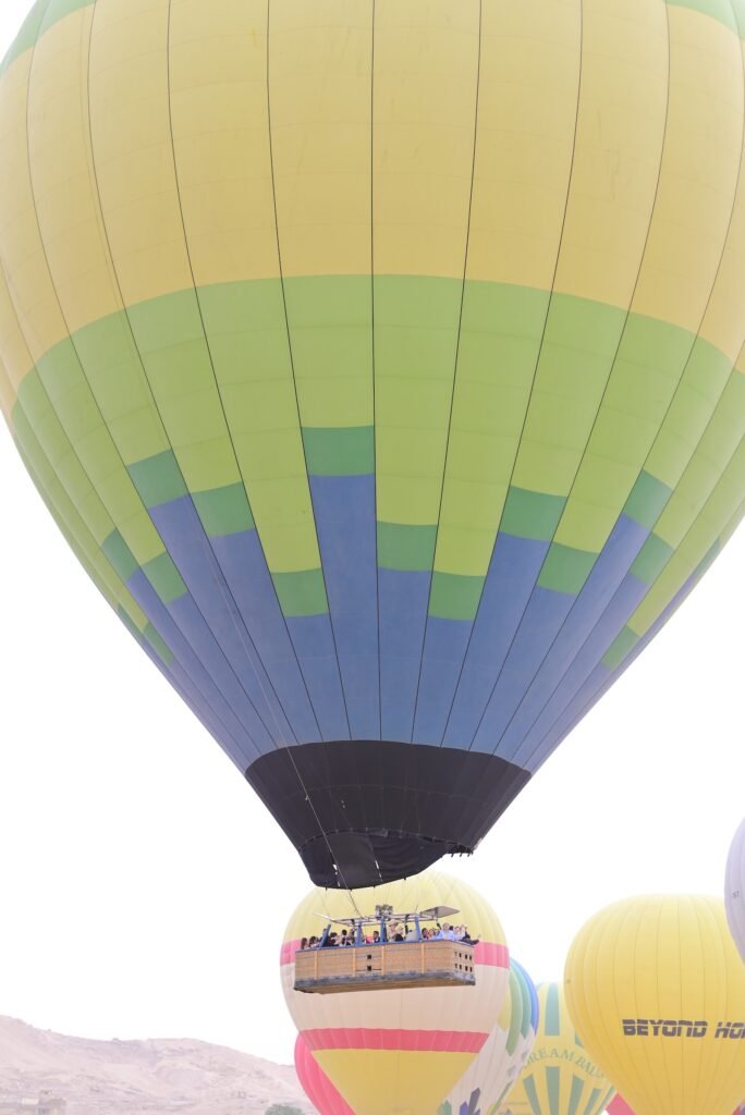 The striped canopy of a large hot air balloon standing inflated on the Luxor launch field