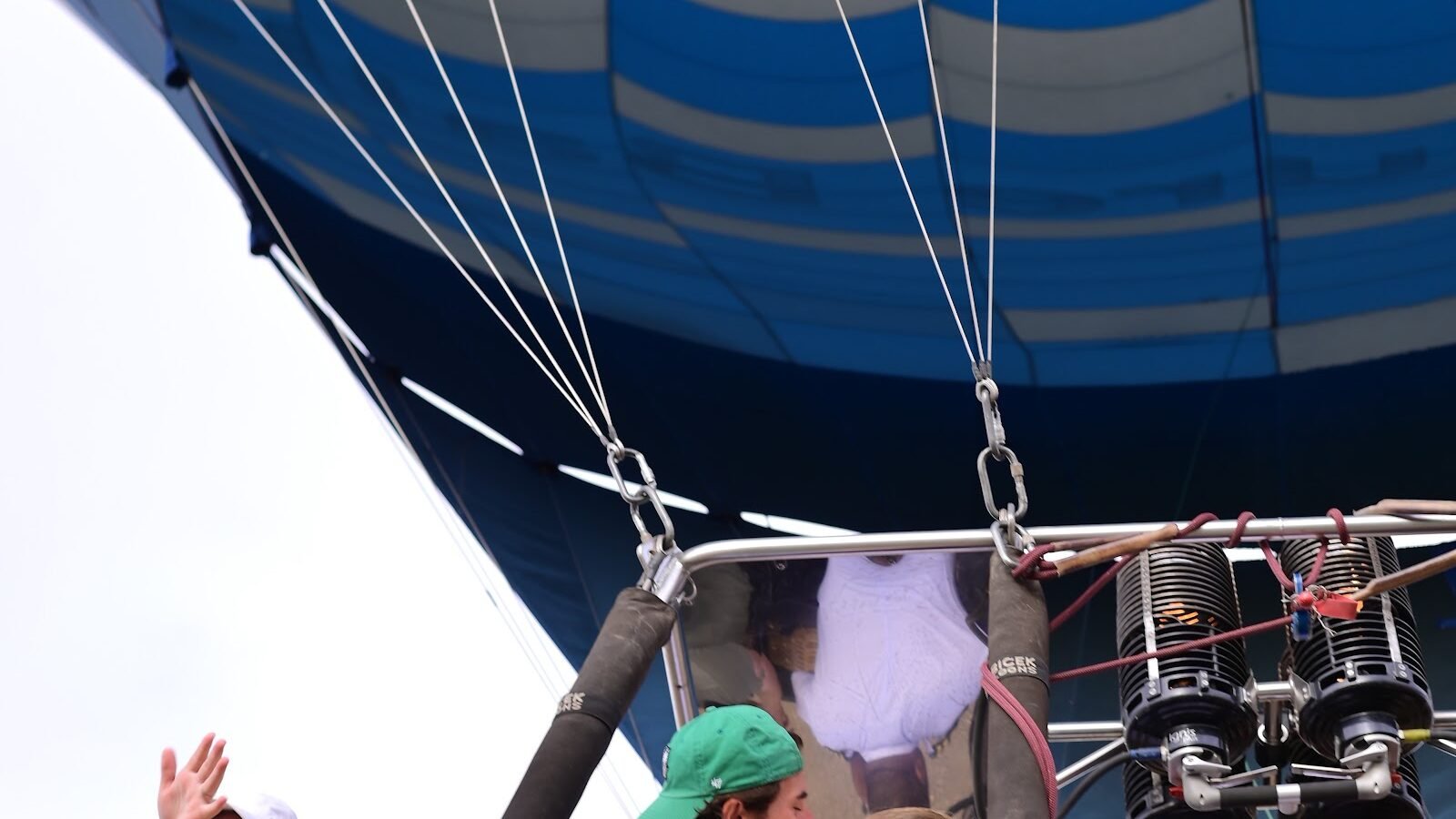 A hot air balloon basket and its blue checked envelope seen from below on the Luxor launch field