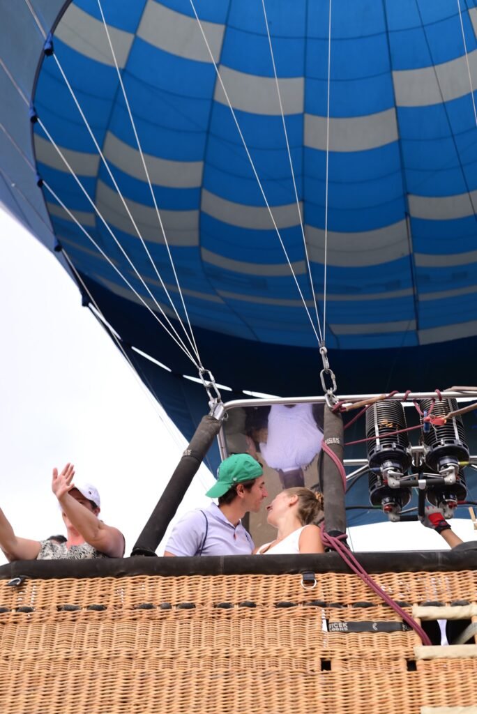 A hot air balloon basket and its blue checked envelope seen from below on the Luxor launch field