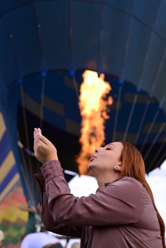 A jet of burner flame filling a hot air balloon envelope during inflation in Luxor