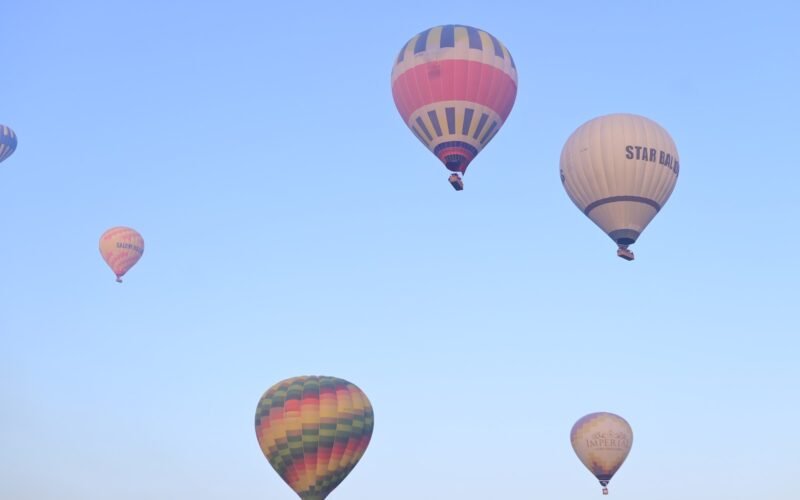 Two hot air balloons high in a clear blue sky above Luxor, Egypt