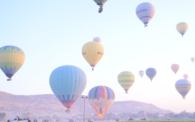 Hot air balloons floating in front of the Theban hills on Luxor's West Bank in early morning light