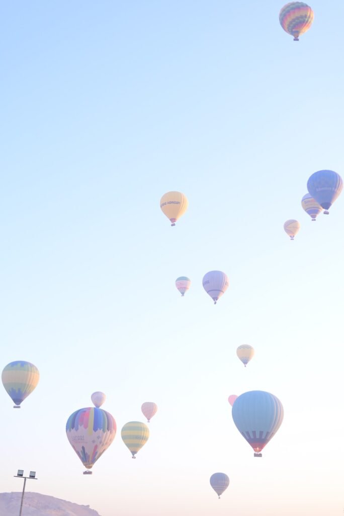 Dozens of distant hot air balloons seen from the air during a sunrise flight over Luxor