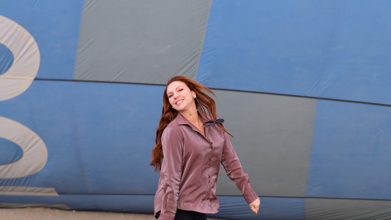 A guest photographed walking beside the blue envelope of a hot air balloon in Luxor